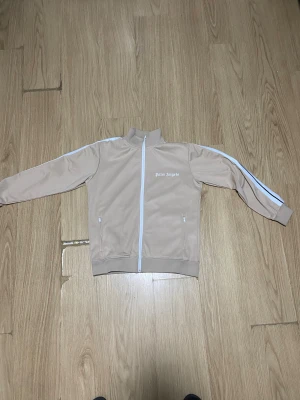 Palm angels Beige - Hej Säljer denna fina palm angels full zipen. Jag säljer den pågrund av den inte andvänds längre. Den är fortfarande i bra skick nästan som ny. Storlek S och passa både kvinna o man. Kan sänka lite
