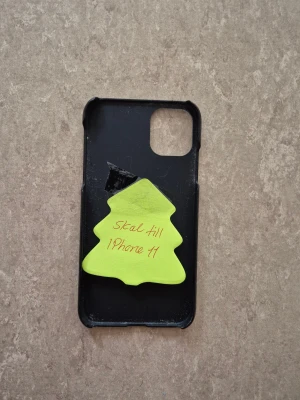 Mobilskal - Snyggt svart skal till iPhone 11 från iDeal of Sweden. Skalet har viss yttre slitage och en mindre skada på insidan, men är fortfarande funktionellt och skyddar din mobil effektivt. Passar perfekt för dig som vill ha ett stilrent och prisvärt skydd.