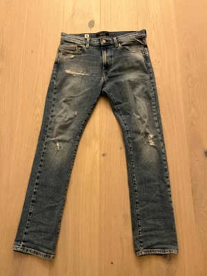 Replay blå jeans med slitningar - Ljusblåa replay jeans med slitningar, slim fit. Dessa jeans passar någon som är ca 159-165