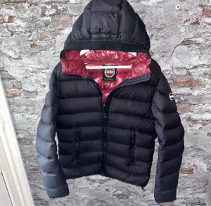 Svart Colmar dunjacka med huva - Unik Colmar jacka i storlek small. Hör av dig vid frågor!