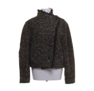 Ulljacka Isabel Marant  - Säljer en mörkgrön, kort kappa från Isabel Marant Étoile med snyggt fiskbensmönster och stora knappar framtill. Jackan har hög krage med råa kanter och är gjord i en mix av ull, akryl, polyester och alpacka. Perfekt för dig som vill ha en unik och trendig look.