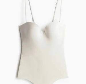 Body - Säljer denna jättefina body från h&m i beige/vit. Den är köpt på plick men jag har inte använt den något. Storlek 75A men passar nog 75B också! Obs!! Den saknar banden som hör till, fick inte med dom när jag köpte❤️