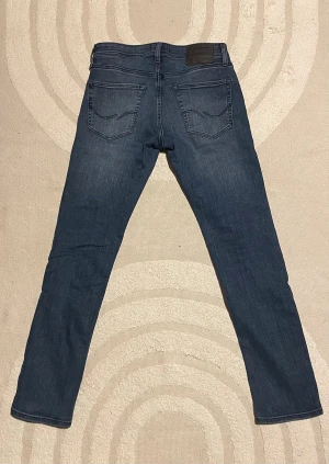 Jack & Jones jeans (Glenn) - Säljer ett par mörkblå slim/skinny jeans från Jack & Jones. Jeansen har normal passform i midjan och smalare ben. Väldigt bekväma jeans. Bara och skriva vid fundering.