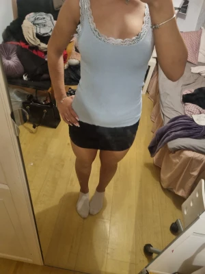 Ljusblå ribbad linnetopp med spets - Supersöt ljusblå linnetopp med ribbad struktur och vit spetskant runt urringningen. 