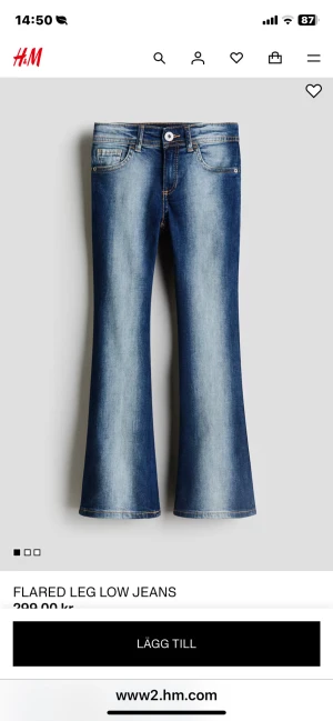 Blå flared low waist jeans från H&M - Snygga blå kvarg jeans från H&M med flared ben och låg midja. Jeansen har klassisk femficksdesign, slitna tvättade detaljer och kontrastsömmar. Perfekta för dig som vill ha en retro vibe och markerad siluett. (Lappen är kvar)