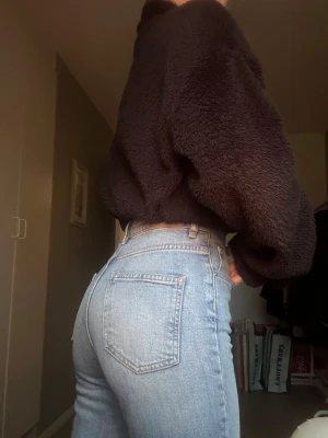 Ljusblå high waist jeans med slitningar - Ljusblå jeans med hög midja och slitningar vid knäna. 