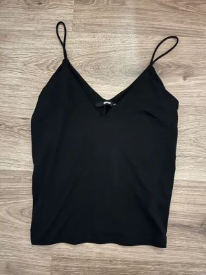 Svart linnetopp med smala axelband -  svart linnetopp med smala axelband och v-ringad hals. Aldrig andvänt