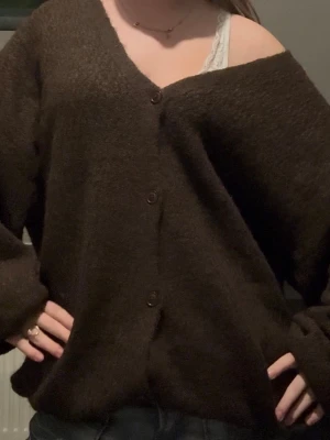 Mörkbrun oversized kofta med knappar - Säljer en mysig mörkbrun kofta med v-ringning från Nelly på grund av att den inte kom till användning! Nyinköpt med lappen kvar och endast testad en gång! Orginalpris är 599 kr, men säljs ej längre. Kontakta mig om du har någon fundering, pris kan såklart alltid diskuteras!❣️