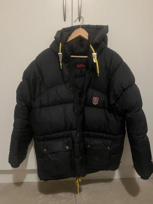 Dunjacka från Fjällräven - Säljer en svart dunjacka från Fjällräven i XS herr storlek. Den är stor i storleken och når midjelängd. 