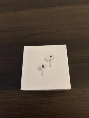 Apple AirPods Pro generation 2 - Säljer ett par vita Apple AirPods Pro2  med laddningsetui, extra silikonpluggar och laddkabel. Hörlurarna är kompakta, har stilren design och levereras i originalförpackning. Perfekta för musik, samtal och sopiga dagar på stan.