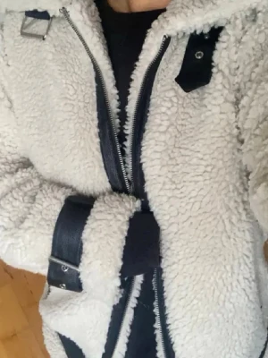 Vit teddyjacka med svarta detaljer - Superfin teddy jacka från bikbok som tyvärr inte kommer till användning. Superfin med svarta detaljer samt fickor på sidan❤️