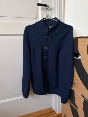 Stenströms cardigan tillverkad i Merino ull från Zegna - Säljer denna schyssta mörkblå cardigan från Stenströms tillverkad i 100% merino ull från Zegna. Den har dessutom mother of pearl knappar med en extra knapp på. Nypris 3500 och är knappt använd. Passar dig som vanligtvis bär S men kan även passa medium om du är kortare än 184. Hör av dig för fler frågor, mvh Charlie