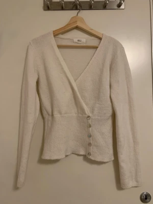 Vit omlottkofta med pärlemorknappar - Populär vit omlottkofta från Gina Tricot, köpt på plick men den är tyvärr för stor för mig. Utgavs för att vara storlek S men kan möjligvis vara M. Utsåld på hemsidan 