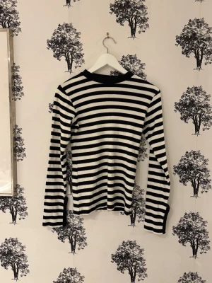 Svartvit randig långärmad tröja - Snygg långärmad tröja med svarta och vita horisontella ränder. Tröjan har rund halsringning och är figurnära i modellen. Perfekt för dig som gillar klassisk och stilren look.