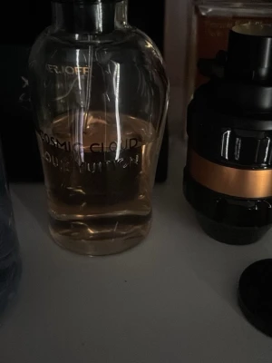 Louis Vuitton Cosmic Cloud parfym - Obs flaskan är tester!! Byten går bra!Exklusiv parfym från Louis Vuitton, Cosmic Cloud. Flaskan är genomskinlig med rundad form och svart lock. Innehållet är ljust bärnstensfärgat och flaskan har elegant tryckt text. Perfekt för dig som gillar lyxiga dofter och snygg design.