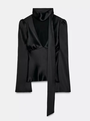 Svart satinsblus med scarfdetalj - ZARA XS - Ny snygg trendig topp! Stilren svart blus i glansigt satintyg med långärmad design och djup v-ringning. Blusen har en snygg scarfdetalj vid halsen som ger en trendig touch. Perfekt för dig som gillar en elegant och modern look.