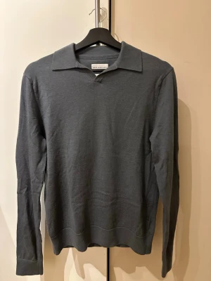 Blå stickad tröja  - En sjukt snygg stickad tröja från these glory days. Tröjan är i en stålblå färg och är gjord av 100% merinoull. Den är sparsamt använd och fortfarande i väldigt gott skick! Nypris är 999kr.