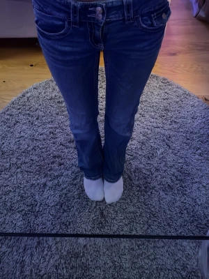 Mörkblå bootcut jeans - Säljer ett par mörkblå jeans med klassiska fickor och bootcut