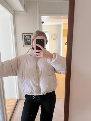 Ljusbeige pufferjacka med dragkedja - Säljer en ljusbeige pufferjacka med hög krage, i bra skick!