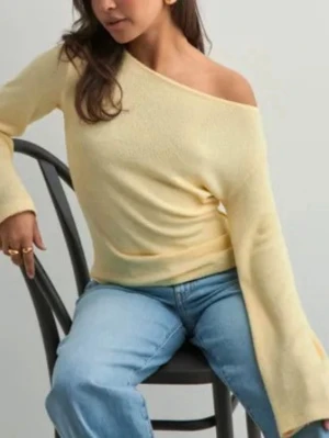 Gul off shoulder tröja - Trendig ljusgul tröja med off shoulder-design och vida ärmar. ’wide sleeve sweater’ från Nelly i storlek M. Mjuk och skön stickning som inte sticks/kliar alls! Aldrig använd. Original pris 280kr Pris kan diskuteras