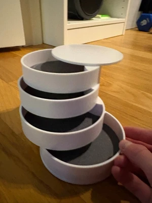 Vit snurrande smyckesförvaring - Snygg och praktisk smyckesförvaring i vit plast med flera runda fack som snurras ut för enkel åtkomst. Perfekt för att organisera ringar, örhängen och andra små accessoarer. Modern och stilren design som passar på sminkbordet eller i garderoben.