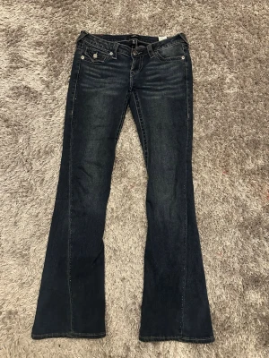 Slutsålda true religion jeans - Slutsålda mörkblå jeans med crystaller längs sömmen, ett av mina favorit jeans men då de inte passar längre har jag valt att sälja, de är ursnygga och piffar upp alla outfits de har en bootcut/flare pass form. Skulle säga att de passar tjejer med storlek S. Några kristaller har lossnat men inget man tänker på! Tveka inte att skriva om ni har frågor, ha det fint! Pris kan diskuteras vid snabb affär