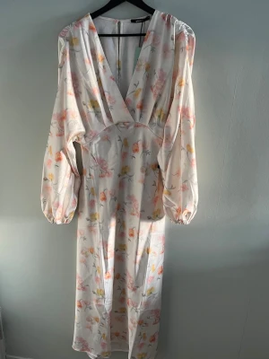 Lång blommig klänning med puffärmar - Säljer denna fina klänning från Gina Tricot då den inte passar🌸Helt ny och oanvänd med prislapp kvar☺️