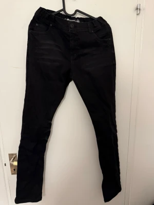 Svarta slim fit jeans från ADRIANO - Säljer ett par svarta slim fit jeans från ADRIANO. Jeansen har klassisk femficksdesign, normal midja och raka ben. Materialet är mjukt och stretchigt för extra komfort. Perfekta till en avslappnad och trendig look.
