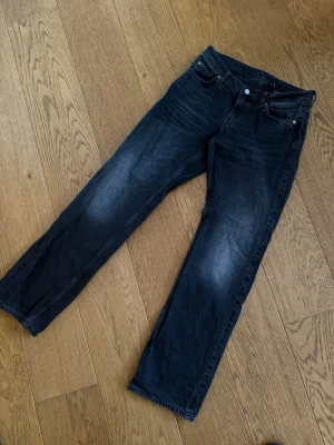 Grå/svarta lågmidjade jeans  - Ett par lågmidjade grå/svarta Arrow jeans ifrån weekday. Dessa jeans är raka och i storlek 27/32. Skicket är väldigt bra då det nästintill aldrig kommit till användning! 
