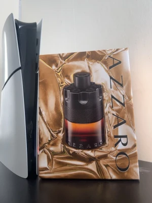 Azzaro Wanted parfymset - Snyggt parfymset från Azzaro med en mörkbrun och svart flaska i metall och glas, en mindre provflaska samt en tub med doftande lotion. Förpackningen har en lyxig guldig design och parfymflaskan har en unik, maskulin form. 1800kr orginal pris present