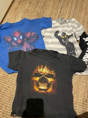 3-pack Spiderman T-shirts Marvel - Tre coola Spiderman T-shirts från Marvel. En blå med klassiskt Spiderman-tryck, en grå- och vitrandig med svart Spiderman och lång ärm med text, samt en svart med tryck framtill. Perfekta för dig som gillar superhjältar!