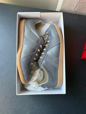 Maison Marigiela Gats  - Maison Margiela GATs i grå färg 🤍 Helt nya — aldrig använda, med all originalförpackning. Klassisk och tidlös sneaker med lyxig känsla, perfekt för både vardag och uppklädda outfits.  Storlek 44  📦 Redo att skickas idag 🚚 Snabb leverans‼️