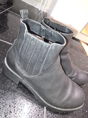 Svarta boots i skinn - Klassiska svarta boots i skinn. Grov sula för extra grepp och komfort. Perfekta för höst och vinter.