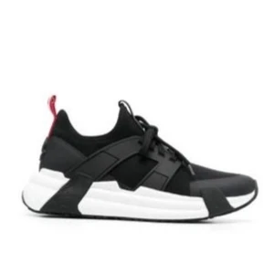 Moncler skor - Snygga svarta sneakers från Givenchy med chunky vit sula och röda detaljer på hälen. Skorna har en modern design med svarta paneler och snörning framtill. Tillverkade i en mix av textil och läder för en sportig och stilren look.