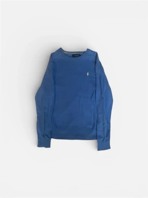 Blå tröja från Polo Ralph Lauren - Snygg blå tröja från Polo Ralph Lauren med rund halsringning och klassisk gul broderad logga på bröstet. Tröjan har långa ärmar och ribbade muddar vid ärmslut och nederkant. Perfekt för en stilren och avslappnad look. Den passar ca xs-s.