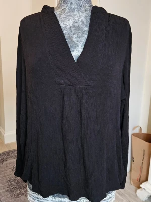 Svart blus  - Enkel blus med v-ringas hals. Lång ärm och något oversize