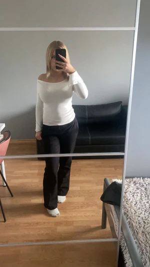 Svarta  kostymbyxor - Snygga svarta kostymbyxor med bootcut-snitt och klassisk midja. Byxorna har en stilren look med pressveck framtill och är perfekta för dig som gillar en clean och modern stil. Materialet känns mjukt och har en lätt stretch för extra komfort.