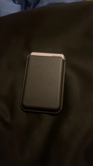 Svart skinnplånbok med kortfack - Minimalistisk svart plånbok i skinn med plats för flera kort. Plånboken har ett smart tumgrepp på baksidan för enkel åtkomst till dina kort. Stilren och kompakt design som passar perfekt i fickan.