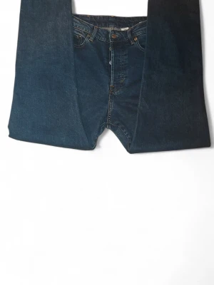 Mörkblå jeans från &Denim - Snygga mörkblå jeans från &Denim med klassisk femficksdesign och raka ben. Jeansen har normal passform och är tillverkade i slitstarkt denimtyg med kontrastsömmar. Perfekt för dig som gillar enkel och tidlös stil.