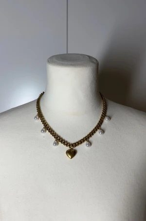 Halsband med pärlor och hjärta - Handgjort kedjehalsband med pärlor. Kedjan är 7mm bred och 45cm lång. Allt i rostfritt stål förutom pärlorna. Fast pris satt efter materialkostnader och tillverkning. Köp gärna via köp nu, snabb leverans.