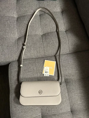 Mk väska - Mk väska med justerbart axelband finns fack för kort inuti väskan 