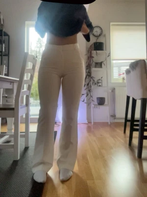 Vita bootcut-byxor från Bik Bok - Säljer ett par snygga vita bootcut-byxor från Bik Bok i storlek 38. De har hög midja, bälteshällor och en stilren look med raka ben som blir lite vidare nedtill. Materialet känns mjukt och har en lätt stretch för skön passform.
