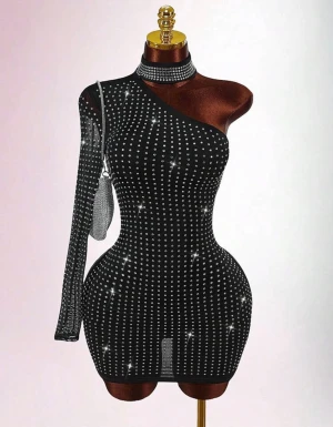 Svart glittrig oneshoulder kortklänning - Supersnygg svart kortklänning med glittriga stenar över hela tyget. Klänningen har oneshoulder-design med en lång ärm och en axel bar. Tight passform som framhäver figuren och ger en riktigt partyvibe. Materialet känns stretchigt och bekvämt.