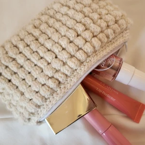 Necessär - virkad - Virkad necessär med bubbelmönster, gjord av mig! Kan användas som sminknecessär, penfodral eller annat. Garnet är merino ull och jag har sytt in blommigt innertyg samt dragkedja💕