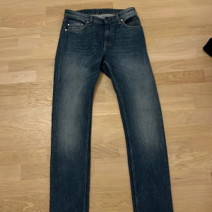 Blå jeans från Whyred - Snygga blå jeans från Whyred med klassisk femficksdesign och diskret tvättad look. Jeansen har raka ben och normal passform, perfekta för en stilren och avslappnad outfit. Tillverkade i slitstarkt denimtyg.