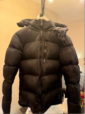 Svart dunjacka från Polo Ralph Lauren S/XS - Säljer en svart dunjacka från Polo Ralph Lauren med huva och tvåvägsdragkedja. Priset går och diskutera. 