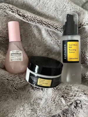 Watermelon Niacinamide Serum & Snail Mucin Essence - Säljer ett rosa Watermelon Niacinamide Serum från Iboccando med pumpflaska, samt Fatazen Snail Mucin 96% Repairing Essence i frostad flaska med svart pump. Inkluderar även en svartvit burk med Advanced Snail 92 All in one Cream. Perfekt för glow och återfuktning.
