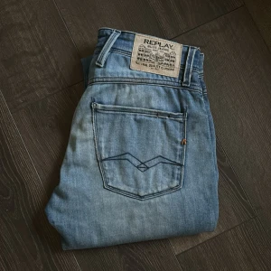 Replay Anbass Jeans - Tja, säljer nu ett par Replay Anbass jeans i blå färg och lite ljusare tvätt. INGA DEFEKTER. Har alla klassiska Replay Detaljer så som metall ”R”, stuket på bakfickorna och alla andra Replay detaljer. Anbass är lite mer av en slim-stretch passform, perfekt för dig som gillar stilrena och bekväma jeans. Storleken är W28 L32.❗️jag har storlek W30 L32 och de passar mig, så stretchen gör sin grej👍🏻             Hör av er gärna vid frågor eller ifall ni vill ha bilder på hur dom sitter😎