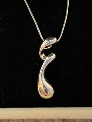 Silvrig halsband med modern hängsmycke - Helt oanvänd silverhalsband från Guldfynd. Kvitto finns på bilden. Kan tyvärr inte byta eller lämna tillbaka det. Jätte fint men kommer tyvärr inte att använda det. Kedja 42 cm