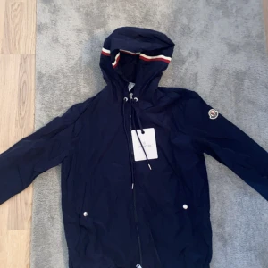 Moncler vindjacka Navy - Navy Moncler Windbreaker. Storlek 1 (Motsvarar S). NFC scan fungerar. Tar ej emot byten och priset går tyvärr ej att diskuteras. Fråga gärna för fler bilder eller funderingar. 